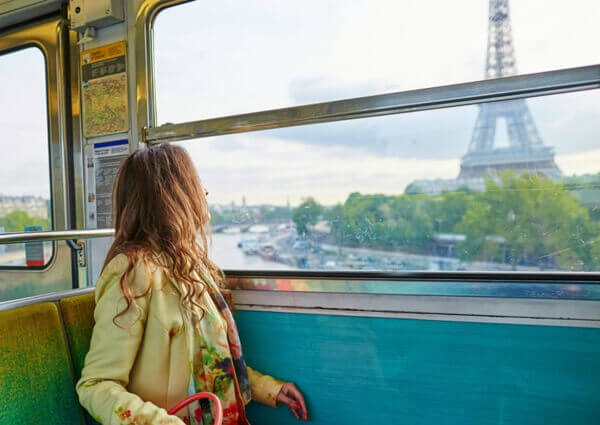 Mujer observa el paisaje abordo de un tren.